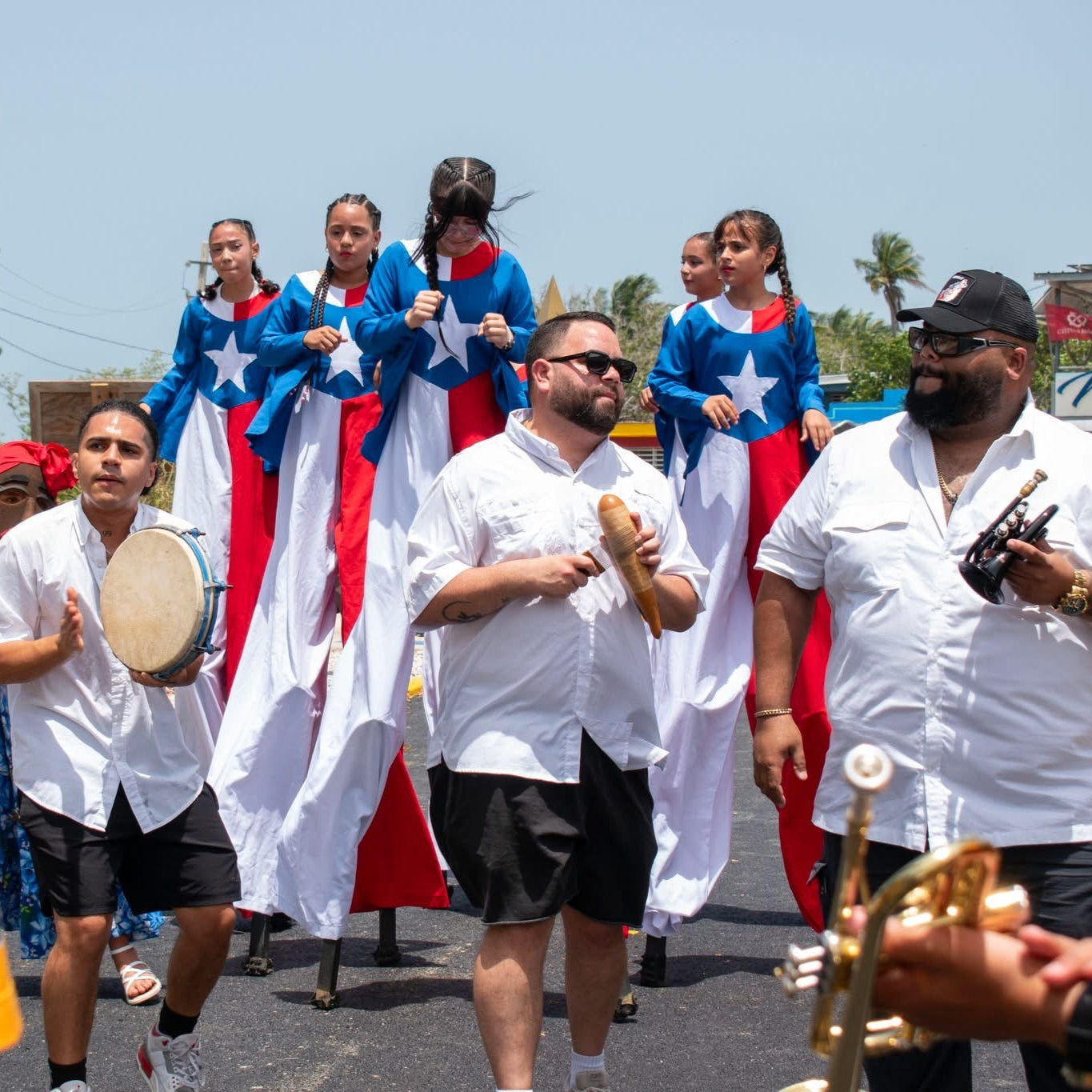 Group of people participating in a parade with flags and musical instruments.